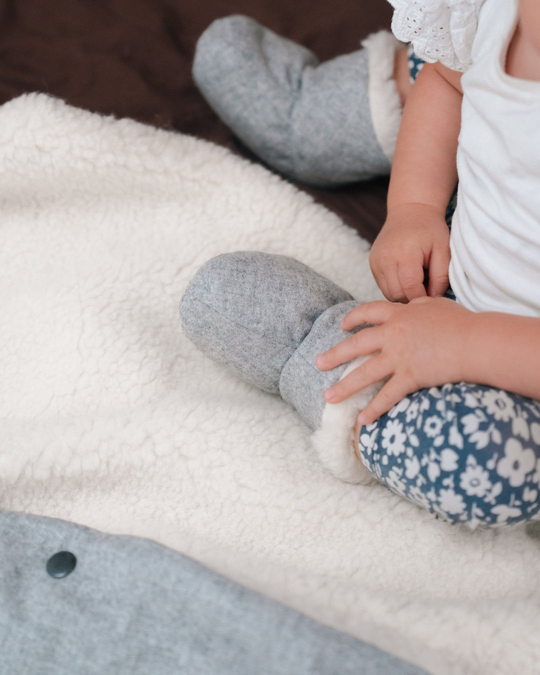 Baby auf Känguru-Kuscheldecke Merinowolle hellgrau