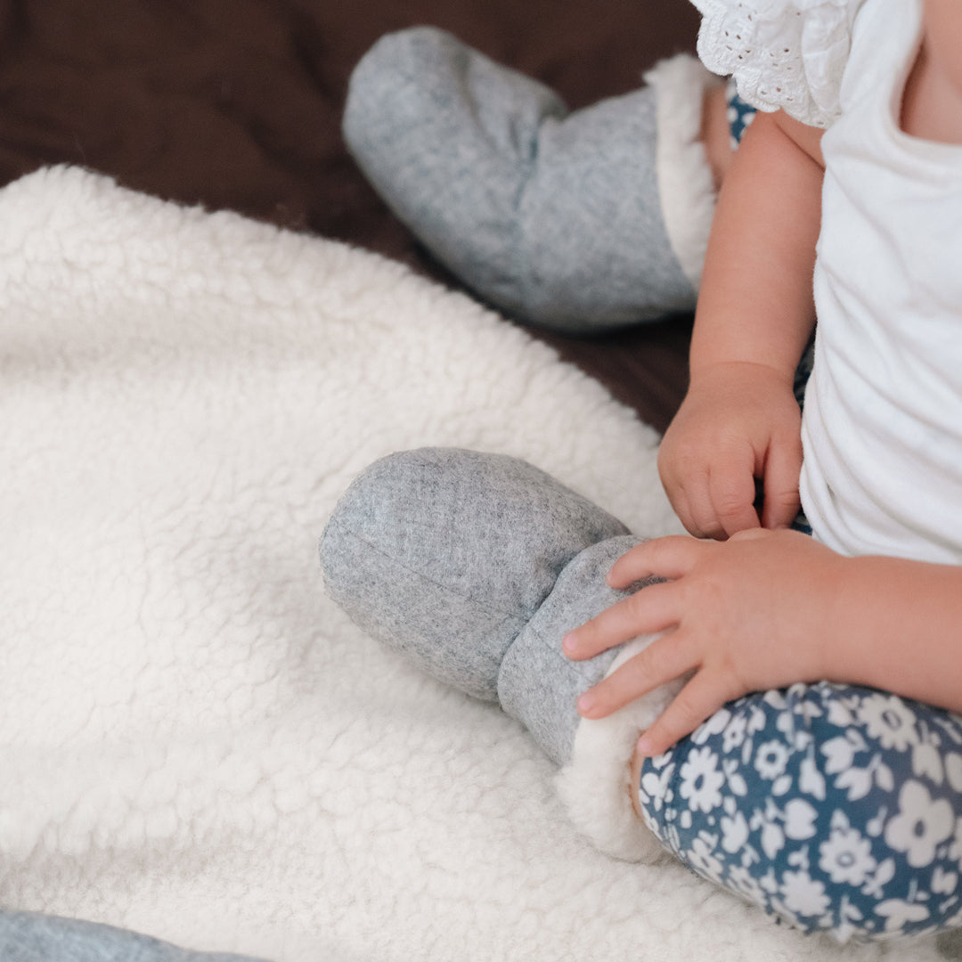 Baby auf Känguru-Kuscheldecke Merinowolle hellgrau